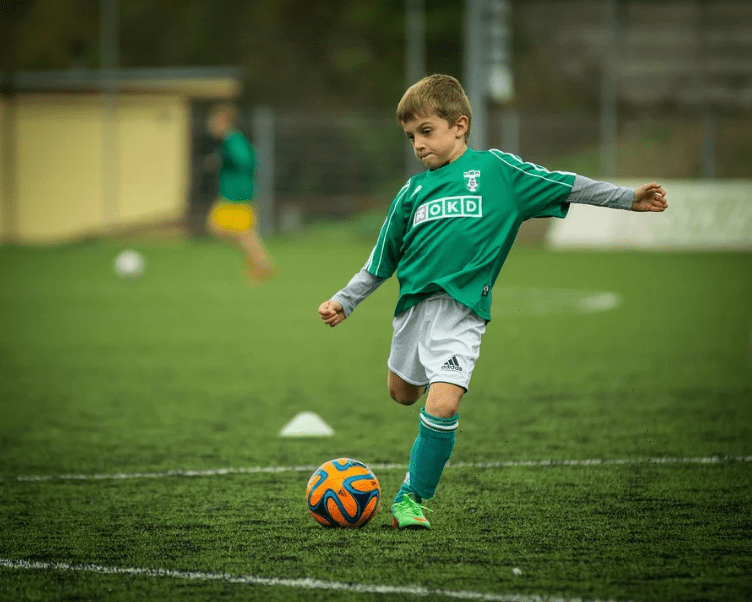 A boy kicking a soccer ball