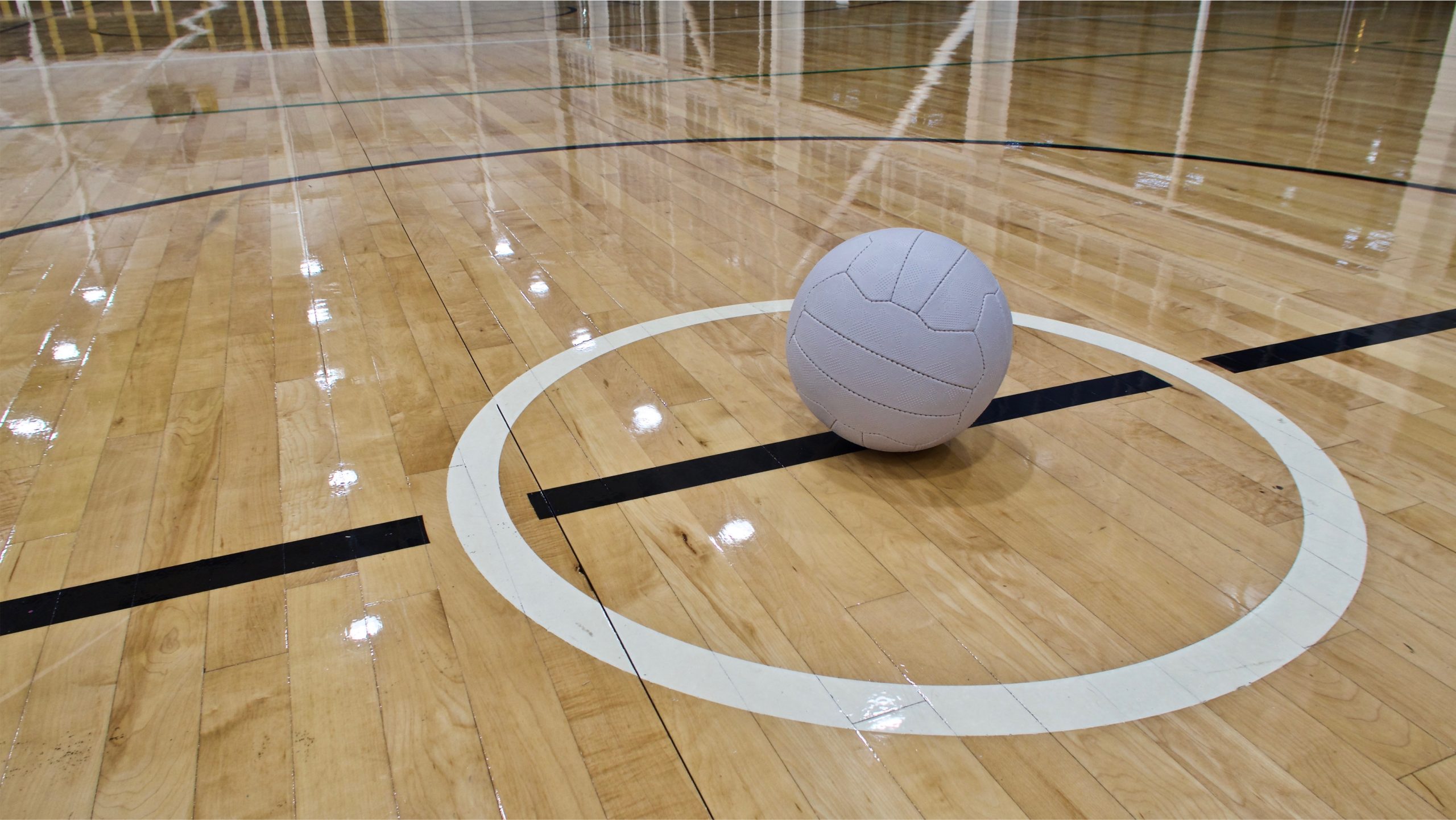a-netball-ball-placed-in-the-centre-circle-of-an-indoor-netball-court