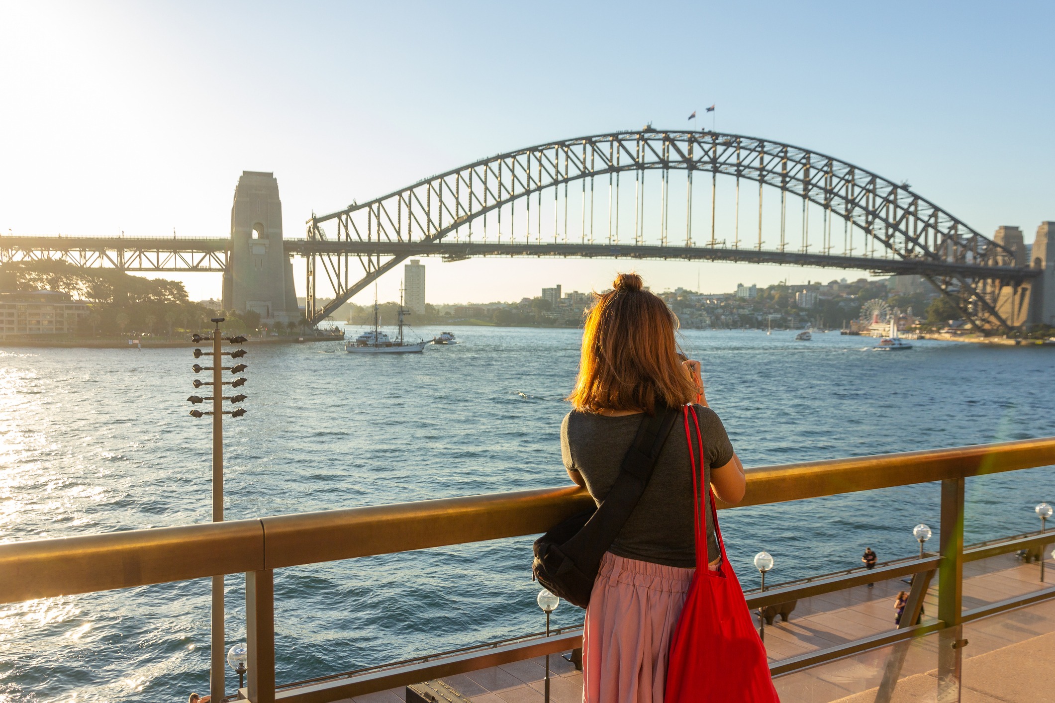 female-tourist-with-backpack-bag-taking-photos-of-sydney-harbour-bridge-during